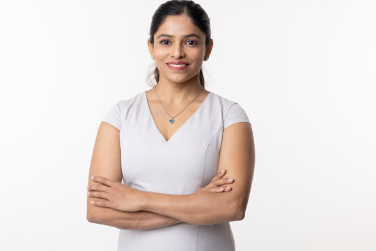 Portrait of smiling businesswoman with arms crossed on white background