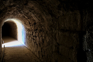 Stone tunnel with light at the end