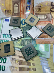 Closeup of golden plated CPUs on Euro banknotes.200 EURO 100 EURO 50 EURO