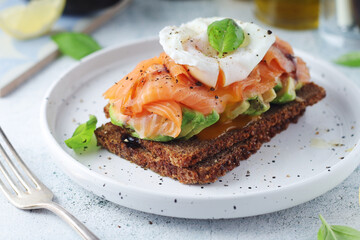 A rye bread sandwich with avocado and salmon