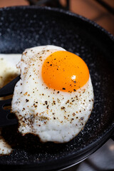 breakfast preparation, fried egg in a frying pan, closeup