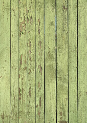 A green fence made of wooden planks. Peeling paint, desolation, background