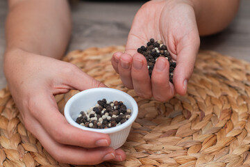 Bowl of Whole Peppercorns in a Female Hands. Gently holding a ramekin filled with assorted whole peppercorns.