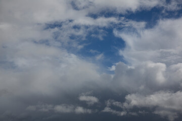Cloudy sky with white clouds and a cloudless area with blue sky