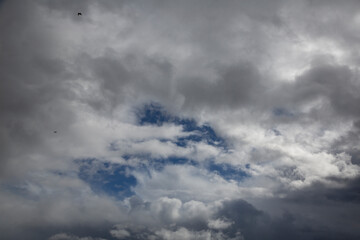 Cloudy sky with white clouds and a cloudless area with blue sky