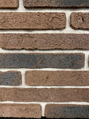 The wall is lined with decorative stone, beautiful seams, background. For the facade of the house, fence