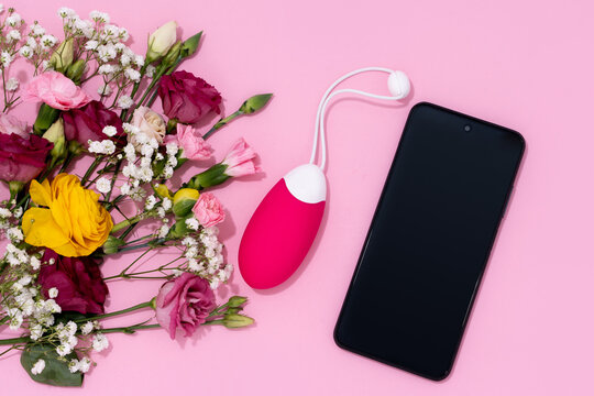 Modern intimacy, showcasing a vibrator adult toy alongside a smartphone with pink flowers