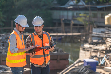 Construction engineer working on a bridge construction site over a river,Civil engineer supervising work,Foreman inspects work at a construction site,Discuss technical problems together