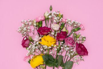 Obraz na płótnie Canvas Vibrant flowers spread out on a pink background for a joyous visual