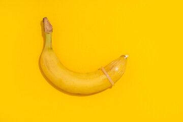 Banana with Condom on yellow background. Sexual Health and Education Concept