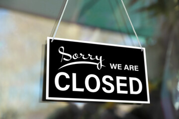 Sorry we are closed sign hanging on glass door