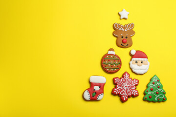 Different tasty Christmas cookies on yellow background, flat lay. Space for text