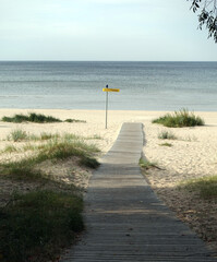 Wooden walk path to passive recreation area to the empty sandy beach on Baltic sea coast in Latvia Jurmala resort in low season