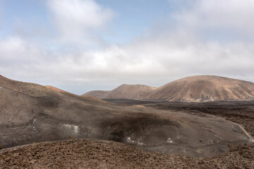 View over multiple small volcanoes among vast lava fields in Timanfaya National park, Lanzarote, Canary islands
