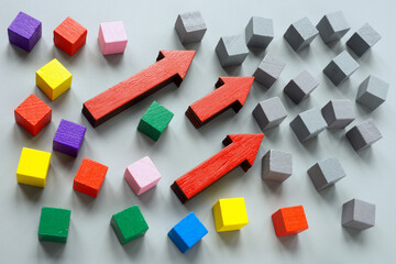 Gray cubes, arrows and colored ones as a symbol of diversity and inclusion.