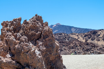 Chaotic rock formations and fine pumice field in Teide National Prk with the Teide volcano on the background