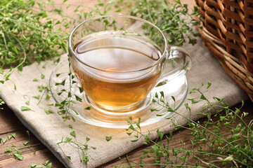 Shepherd's purse tea or infusion in glass cup on linen textile on wooden rustic table, natural medicine and healthy plant remedy and desease treatment concept