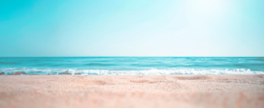 Beautiful summer background with a sandy beach and blue sea water, close up and blurred, copy space concept. Summer vacation banner template design for travel or decoration background
