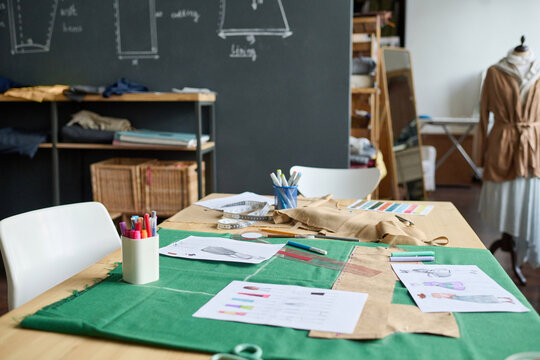 Background image of atelier workshop interior with sewing patterns on table, copy space