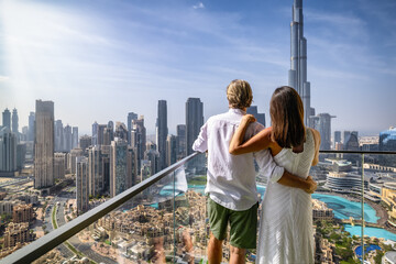 A hugging tourist couple enjoys the elevated view of the skyline of Downtown Dubai, UAE