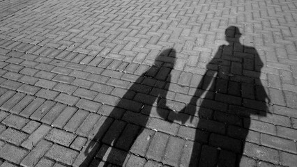 Shadow of father and daughter walking