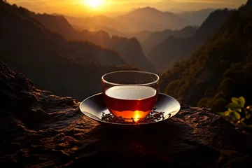 Foto op Plexiglas a cup of tea on a plate with mountains in the background © Serghei11