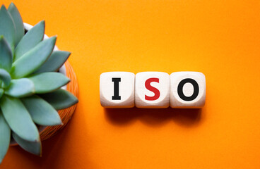 ISO standards quality control symbol. Concept word ISO on wooden cubes. Beautiful orange background...