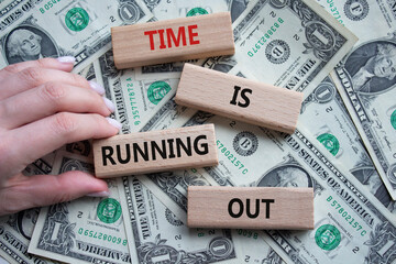 Time is running out symbol. Concept words Time is running out on wooden blocks. Beautiful dollar...