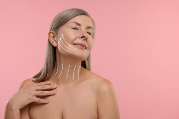 Woman with perfect skin after cosmetic treatment on pink background, space for text. Lifting arrows on her neck and face