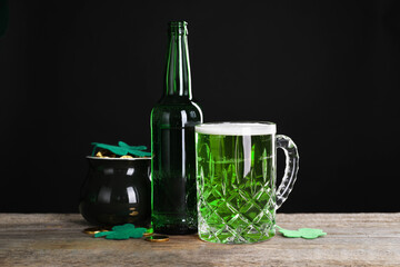 St. Patrick's day party. Green beer, leprechaun pot of gold and decorative clover leaves on wooden...
