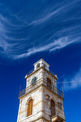 Impressive stone-built belfry with beautiful cloud stripes over an intensevily blue sky, in the picturesque village of Krokos, in Kozani region, Macedonia, Greece, Europe.