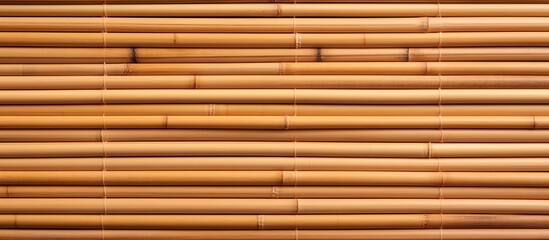 A closeup of a brown bamboo stick wall, showcasing the golden and amber tints and shades of the wood. The rectangular pattern and symmetry create a unique window covering design