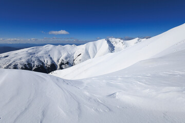 View from Baranec, Western Tatras, Slovakia. Beautiful winter landscape of mountains is covered by snow in wintertime. Sunny weather with clear blue sky and white snow. Wide angle with soft corners.