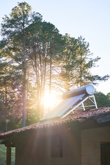 Solar water heater on roof top, cabin in the woods © Fabián Montaño