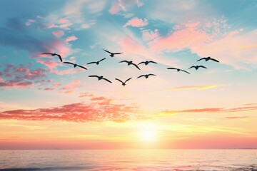 Flock of birds flying over a serene ocean at sunrise with colorful clouds in the sky. Concept of freedom, nature, and tranquility.
