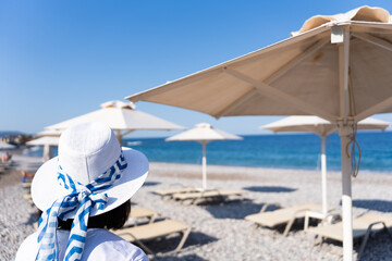 Unrecognizable woman with greek hat on vacation on the island of Rhodes in Greece looking at the...