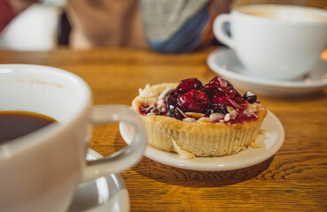 Coffee Cup and Pastry on Table. A scene of a cup of coffee and a pastry placed on a table, creating a cozy and inviting atmosphere.