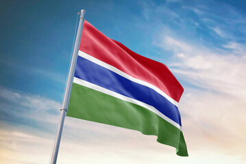 Waving flag of Gambia in blue sky. Gambia flag for independence day. The symbol of the state on wavy fabric.