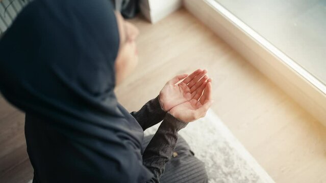 Top view of Muslim woman in hijab praying home, religious ritual, faith in God