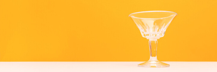 Banner with crystal glass in front of yellow background. Place for text.