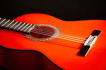 Fototapeta premium Classical Spanish flamenco guitar close up, dramatically lit isolated on black background with copy space.