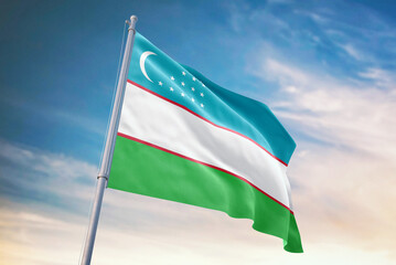 Waving flag of Uzbekistan in blue sky. Uzbekistan flag for independence day. The symbol of the state on wavy fabric.