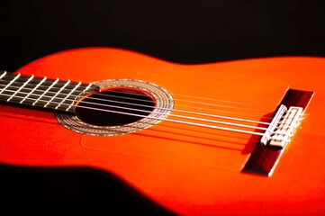 Classical Spanish flamenco guitar close up, dramatically lit isolated on black background with copy...