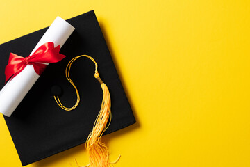 Flat lay composition with graduation hat and diploma on yellow background
