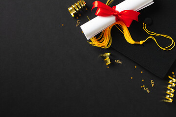 Flat lay composition with graduation hat and diploma on dark background