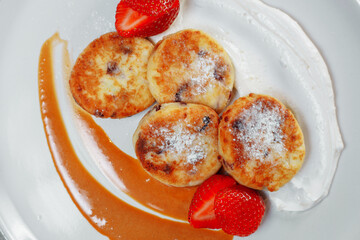 Sweet delicious food for breakfast. Pancake cheesecakes with fresh strawberry, blueberry and maple syrup. Delicious tasty pancake, morning food in cafe. 