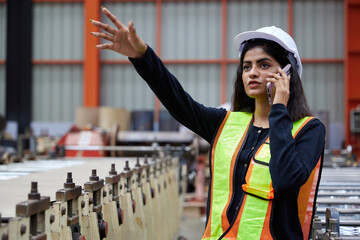 worker or engineer talking on smartphone and looking above in the factory