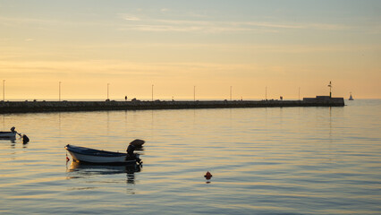 Boats and the pier of Umag at sunset