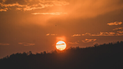 Red sunset over a hill with a close up of the sun