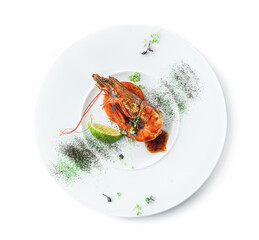 Large grilled tiger shrimp with lime, microgreens and sauce in plate isolated on white background. Healthy seafood, top view